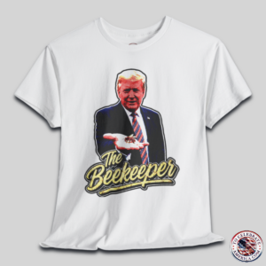 White T‑shirt featuring a pop‑art grunge illustration of President Trump holding a bee in his hand with bold ‘The Beekeeper’ text below.