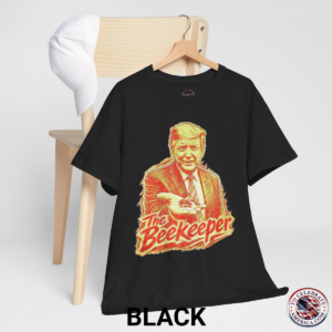 Black T‑shirt featuring a pencil‑sketch illustration of President Trump holding a small bee in an outstretched hand, with stylized ‘The Beekeeper’ text below.