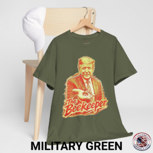 Military Green T‑shirt featuring a pencil‑sketch illustration of President Trump holding a small bee in an outstretched hand, with stylized ‘The Beekeeper’ text below.