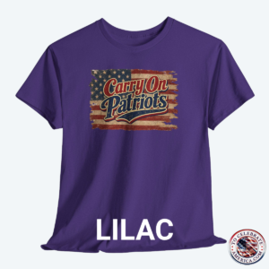 Lilac T‑shirt featuring distressed American flag background with bold ‘Carry On Patriots’ vintage lettering.”