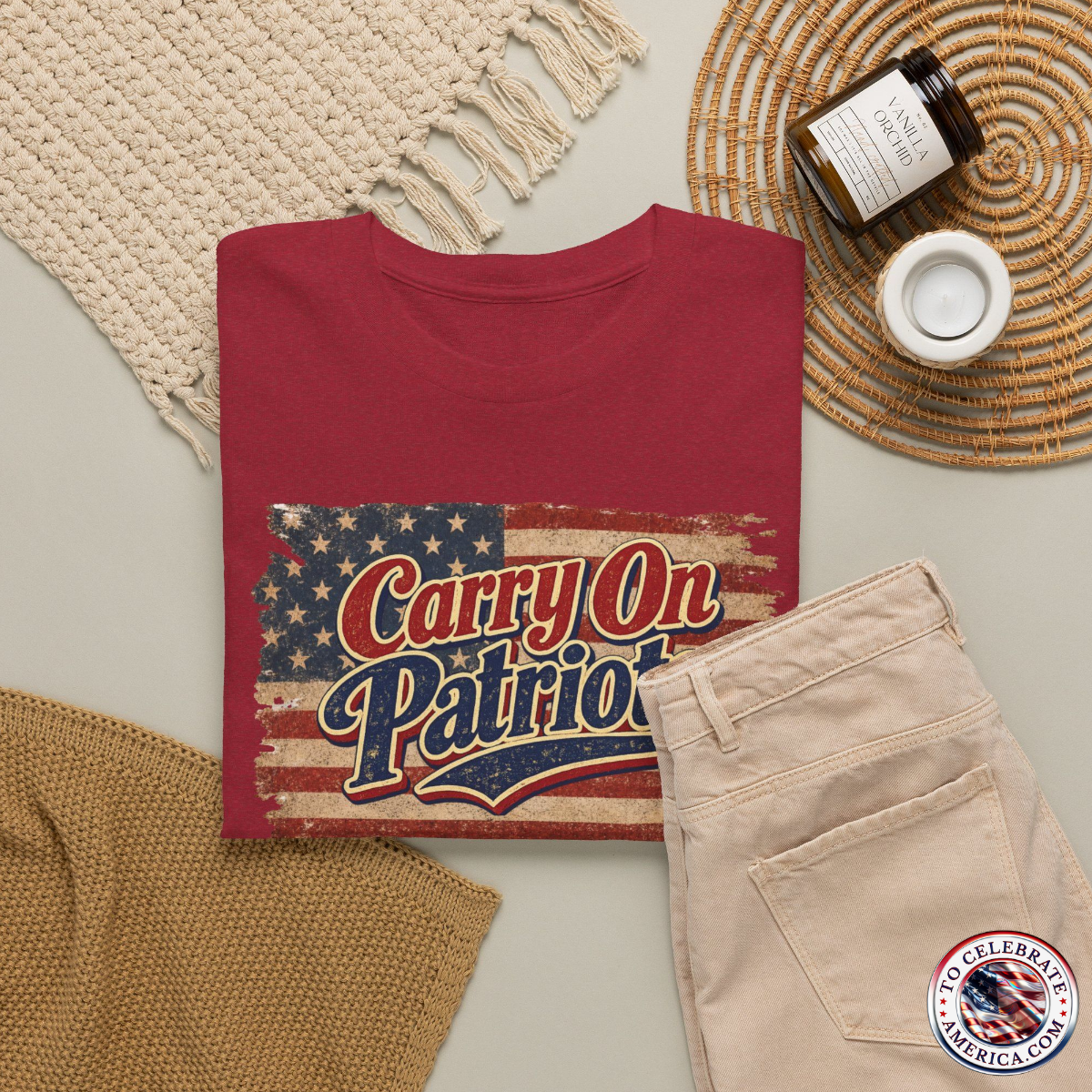 Antique Cherry Red T‑shirt featuring distressed American flag background with bold ‘Carry On Patriots’ vintage lettering. Set against feminine wearing apparel featuring a straw summer hat knitted scarf, slacks, and sunscreen